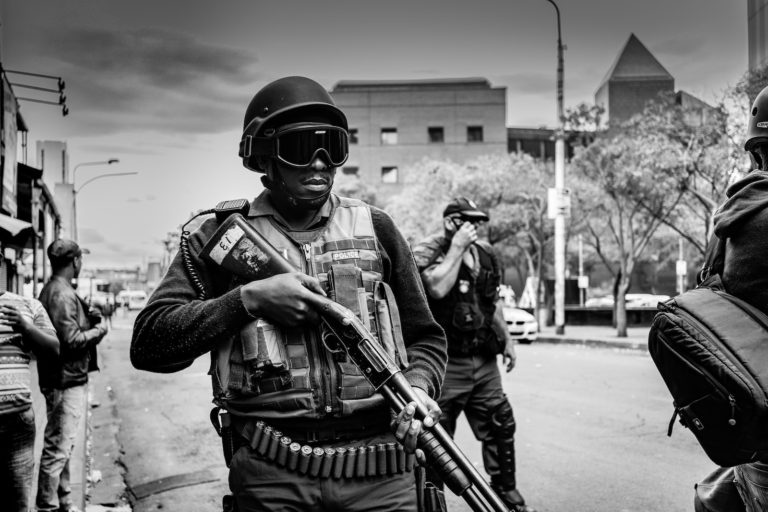 grayscale photo of soldier carrying pump-action rifle