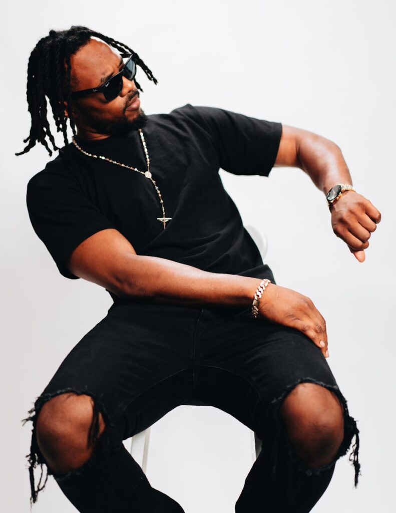 a man with dreadlocks sitting on a chair